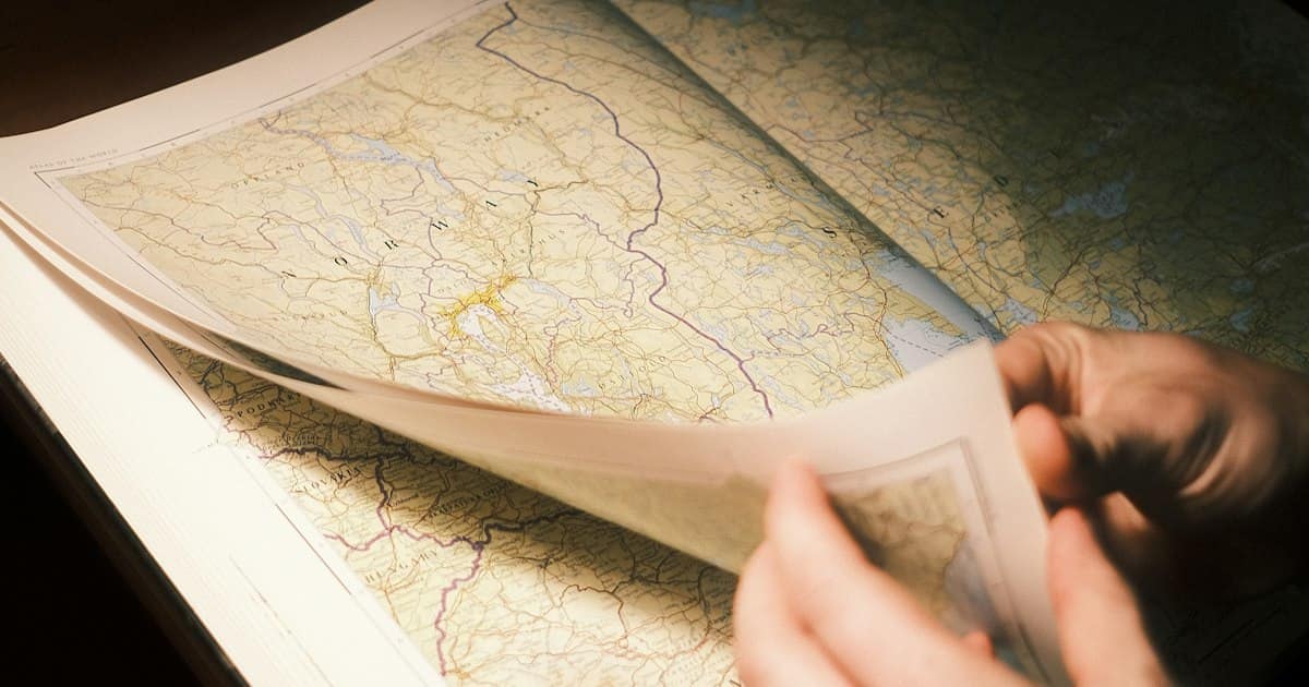 Person looking at a map on a table while researching land